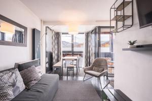 a living room with a couch and a chair at Appartement 6 couchages Val Thorens in Val Thorens