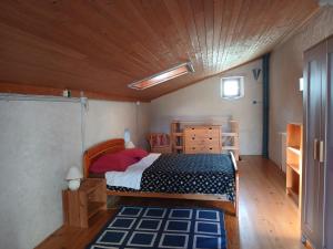 a bedroom with a bed and a wooden ceiling at La Garnasette in Beaulieu