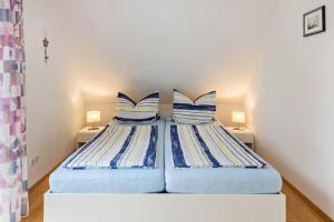 two beds with blue and white pillows in a room at Ferienwohnung Ingrid Heyes in Radolfzell am Bodensee