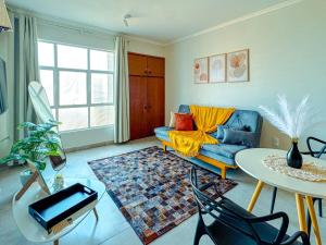 a living room with a blue couch and a table at Studio 43 - Central Coração de Franca in Franca