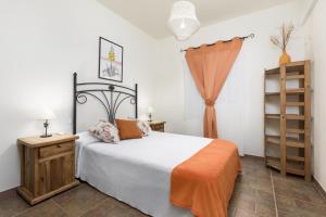 a bedroom with a bed with an orange blanket at Casa Guerepe in La Pared