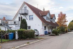 a white house with a red roof at Ferienwohnung Ingrid Heyes in Radolfzell am Bodensee
