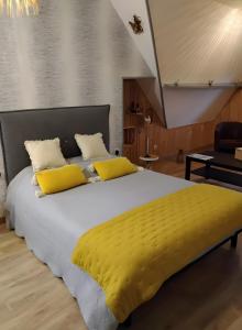 a bedroom with a large bed with yellow pillows at Chambres D'hôtes in Videcosville