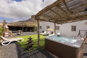 a hot tub in a backyard with a pergola at Casa Guerepe in La Pared