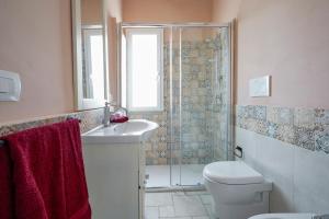 a bathroom with a toilet and a sink and a shower at Casina delle Rose - Scirocco in Polignano a Mare +27 photos