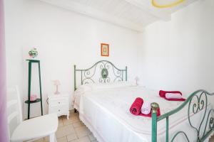 a white bedroom with a white bed with red shoes on it at Casina delle Rose - Scirocco in Polignano a Mare