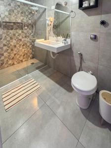 a bathroom with a toilet and a sink and a shower at Studio 43 - Central Coração de Franca in Franca