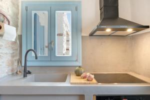 a kitchen counter with a sink and a window at Sylvia's Home in Sifnos +25 photos