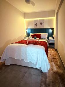 a bedroom with a large bed with a blue headboard at Studio 43 - Central Coração de Franca in Franca +13 photos