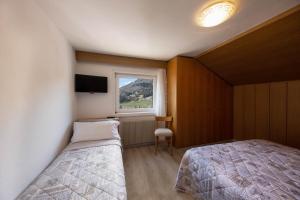 a small bedroom with a bed and a window at Appartamento Primavera 4 in Moena