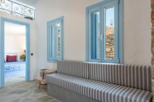 a living room with a couch and two windows at Sylvia's Home in Sifnos