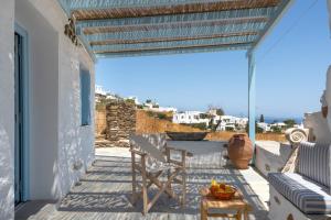 a patio with a table and chairs and a view of the ocean at Sylvia's Home in Sifnos