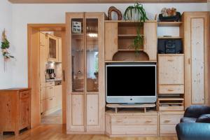 a living room with a tv in a wooden entertainment center at Ferienhaus Blumenstock in Steinsfeld