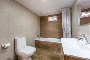 a bathroom with a toilet and a sink and a tub at Noria 2 in Níjar +15 photos