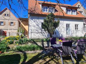 a table and chairs in front of a house at Ferienhaus Blumenstock in Steinsfeld
