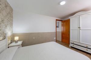 a bedroom with a white bed and a wooden door at Noria 2 in Níjar
