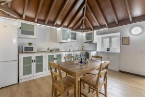 a kitchen with a wooden table and chairs in it at La Gomera in La Victoria de Acentejo