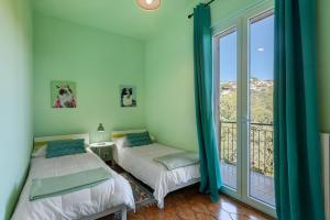 a bedroom with two beds and a balcony at Villa Cristina - vista mare in Boissano