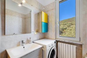 a bathroom with a sink and a washing machine at Villa Cristina - vista mare in Boissano +30 photos