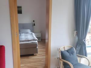 a door to a bedroom with a bed and a chair at Ferienwohnung Rösner in Herzhausen