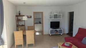 a living room with a couch and a table with a tv at Ferienwohnung Rösner in Herzhausen