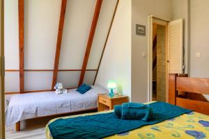 a bedroom with two beds and a lamp on a table at Gite Riesling n°5 à Kaysersberg in Kaysersberg