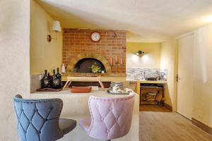 a kitchen with a table and a brick fireplace at Villa Cristina - vista mare in Boissano