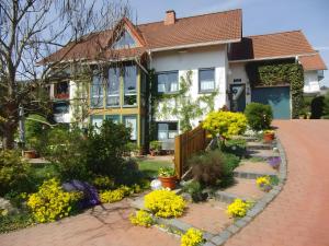 a house with flowers in the front yard at Ferienwohnung Rösner in Herzhausen