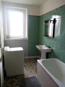 a bathroom with a sink and a tub and a toilet and a sink at Maison quartier Porzic vue Mer in Crozon