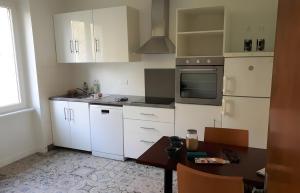 a kitchen with white cabinets and a table at Maison quartier Porzic vue Mer in Crozon +18 photos