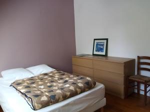 a bedroom with a bed and a dresser and a chair at Maison quartier Porzic vue Mer in Crozon