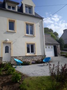 two blue chairs in front of a house at Maison quartier Porzic vue Mer in Crozon