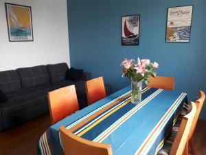 a dining room table with a vase of flowers on it at Maison quartier Porzic vue Mer in Crozon