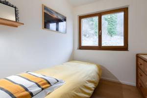a bedroom with a bed and a window at Gite Nature L'orée Des Etoiles in Stosswihr