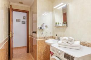 a bathroom with a sink and a washing machine at El Barquillo in La Santa +16 photos