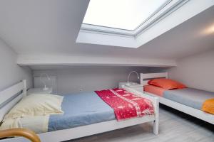 a bedroom with two beds and a skylight at Gite Azur Toulouse Sud in Lherm +21 photos