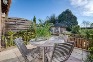 a patio with a wooden table and chairs at Gite Azur Toulouse Sud in Lherm