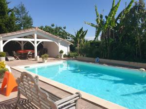 a swimming pool with a chair and a gazebo at Gite Azur Toulouse Sud in Lherm