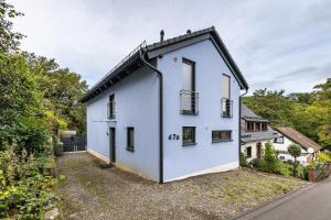 a white house with a black roof at Haus mit 4 Schlafzimmern in Solingen