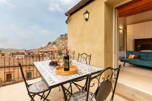 a table with a bottle of wine on a balcony at Vico degli Orti in Mistretta
