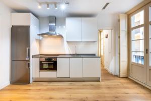 a kitchen with white cabinets and a sink at Apartamento Soho Málaga in Málaga