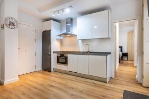 a kitchen with white cabinets and a counter top at Apartamento Soho Málaga in Málaga +11 photos