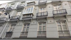 a tall white building with balconies and windows at Apartamento Soho Málaga in Málaga