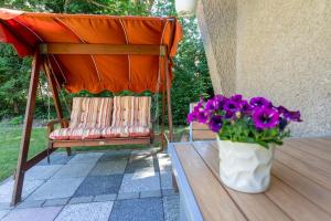 a vase of purple flowers on a table with a chair at Ferienhaus Krohse in Potsdam