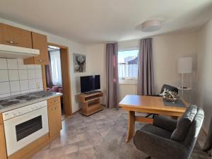 a living room with a table and a kitchen at Haus Barbara Ott in St. Blasien +10 photos