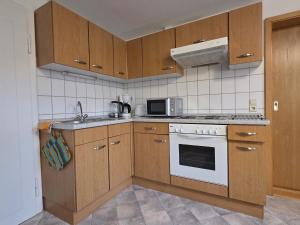 a kitchen with wooden cabinets and a stove top oven at Haus Barbara Ott in St. Blasien