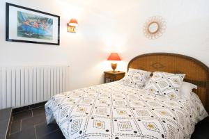 a bedroom with a bed with a white comforter at Entre Terre et Mer in Ciboure