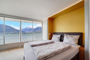 a bedroom with two beds and a large window at Villa Alvarium Eins in Schenna
