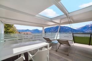 a balcony with a table and chairs and mountains at Villa Alvarium Eins in Schenna