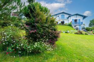 a house on a hill with flowers in the yard at Entre Terre et Mer in Ciboure +8 photos